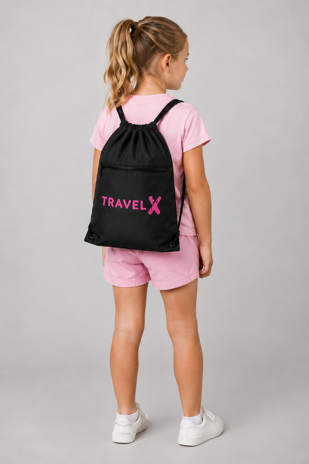 Girl wearing a Travel X Go Bag with pink logo