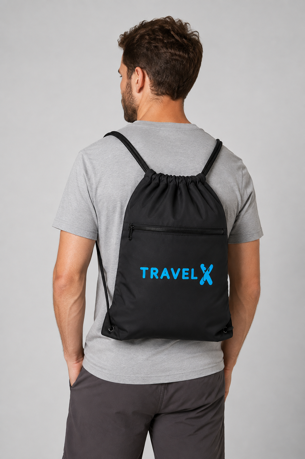 Man wearing a Travel X Go Bag with blue logo